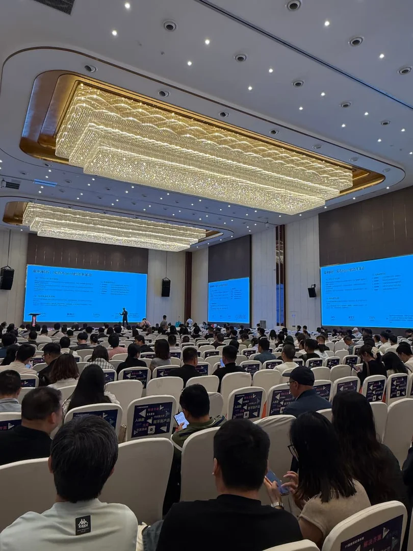 2026 第十届四川系统集成行业千人峰会主席台主视觉广角实拍，舞台中央讲台、左右两侧背景板印有峰会标识与第十届庆典元素