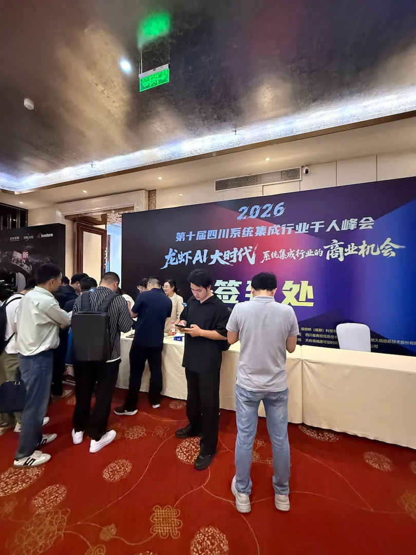 2026 第十届四川系统集成行业千人峰会签到处现场，多列签到台前排队的参会代表，工作人员核验信息发放胸牌与会议手册